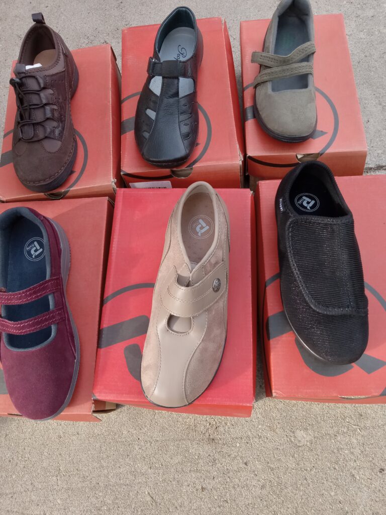 A variety of casual shoes displayed on red boxes.